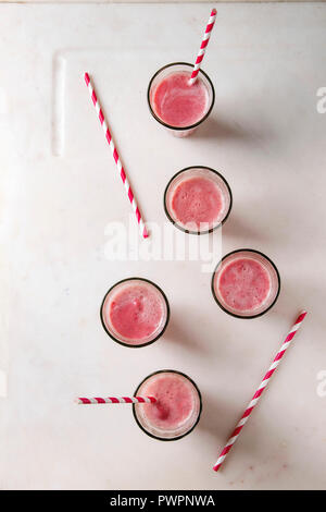 Petits fruits Fruits Rouge pastèque cocktail glacé dans des verres avec paille rayée sur fond blanc en arrière-plan. Boisson froide d'été. Mise à plat, de l'espace Banque D'Images
