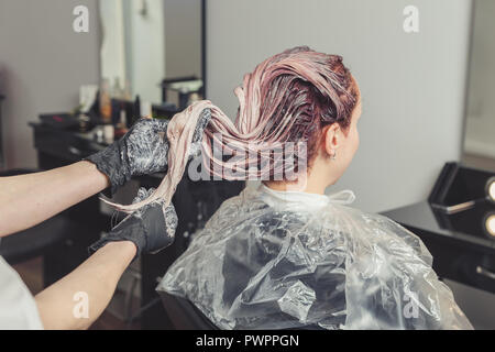 Styliste féminin l'application d'un colorant pour les clients de cheveux à salon de Banque D'Images