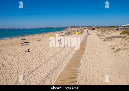 Promenade menant à la plage avec quelques chaises longues. Banque D'Images