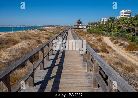 Promenade menant à la plage avec quelques chaises longues. Banque D'Images