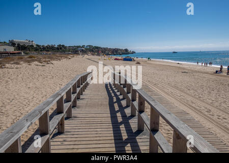 Promenade menant à la plage avec quelques chaises longues. Banque D'Images