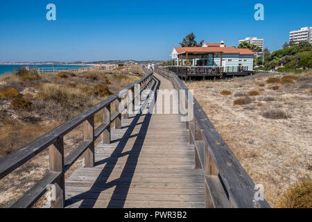 Promenade menant à la plage avec quelques chaises longues. Banque D'Images