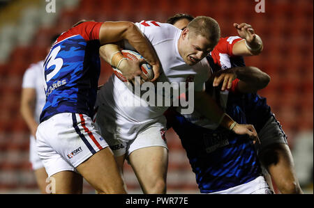 L'Angleterre George Burgess est abordé par l'Mickail Goudemand (à gauche), pendant le match international à Leigh Sports Village. Banque D'Images