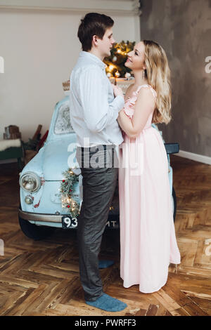 Belle mari embrassant belle blonde woman wearing robe rose. Banque D'Images