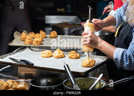 Le remplissage avec un seringue éclairs confiseries avec des mains Banque D'Images
