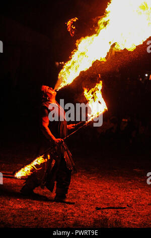 Cracheuse de feu dans la nuit montrent au festival médiéval sur fond noir Banque D'Images