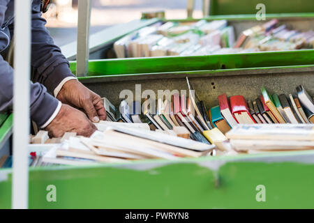 Un homme à la recherche de ses mains de vieux livres dans un grand boxs placés dans un marché de rue à Ancône, en Italie. Banque D'Images