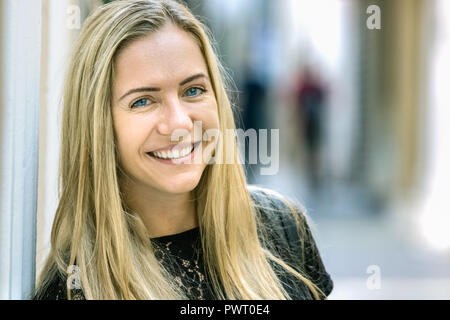 Portrait d'une jeune femme blonde en Pologne, 24 ans, à huis clos, souriant, heureux à l'extérieur. Banque D'Images