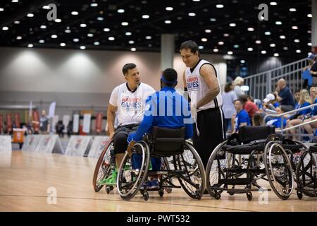 Les anciens combattants de l'armée américaine Armando Gonzales, de Killeen, TEXAS., et Jared Temple Pradorrey, de San Antonio, Texas., conversate avec un membre de l'équipe adverse avant qu'une pratique pour la compétition de basket-ball en fauteuil roulant pour le ministère de la Défense 2017 Warrior Jeux à Chicago, Illinois, le 1 juillet 2017. La DOD Warrior Jeux sont un événement annuel permettant aux blessés, malades et blessés militaires et anciens combattants au style paralympiques sports comme le tir à l'arc, randonnée à vélo, terrain, tir, le volleyball assis, natation, athlétisme et de basket-ball en fauteuil roulant. Banque D'Images