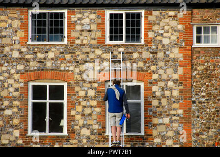 Nettoyant pour vitres sur l'échelle, Norwich, Norfolk, Angleterre Banque D'Images