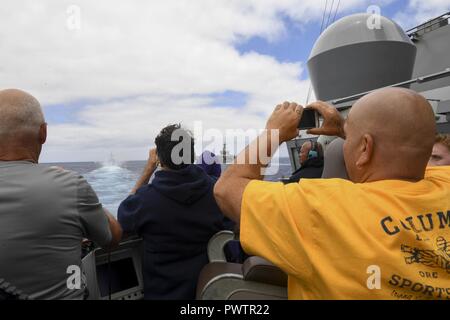 Océan Pacifique (19 juin 2017) Les amis et la famille des membres de l'équipage à bord de la classe Arleigh Burke destroyer lance-missiles USS Wayne E. Meyer (DDG 108) voir de classe Ticonderoga croiseur lance-missiles USS Lake Champlain (CG 57) un incendie 5 canons pour une démonstration de puissance de la mer au cours d'une croisière de tigre. La Marine américaine a patrouillé les Indo-Asia-Pacifique couramment pour plus de 70 ans la promotion de la paix et la sécurité régionales. ( Banque D'Images