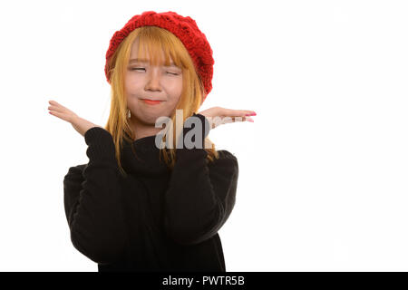 Young cute Asian woman posing with mains près du visage et winki Banque D'Images