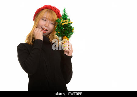 Young happy Asian woman smiling while holding chandail et heureux Banque D'Images