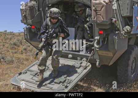 Soldats avec 5e Bataillon, 20e Régiment d'infanterie, de démonter leur véhicule Stryker durant la formation au Centre de formation de Yakima, 21 juin 2017. Les soldats étaient des jeux comme la force opposée et vêtus de noir pour les distinguer que les forces ennemies au cours de discussion baïonnette 17-03. Banque D'Images