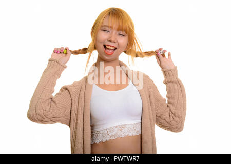 Young happy Asian woman smiling et jouant avec ses cheveux Banque D'Images