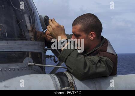 Le Cpl. Rickman Crockett, un CH-53E Super Stallion avec Marine chef de l'équipe de l'escadron 265 à rotors basculants moyen (renforcée), resserre les vis vis au cours d'une vérification de maintenance pré-vol à bord du Bonhomme Richard (DG 6), 22 juin 2017. Le VMM-265 (Rein.) fait partie de l'élément de combat de l'aviation du 31e Marine Expeditionary Unit. L'ACE offre des voies de transports, l'appui aérien rapproché et de commandement et de contrôle de l'aviation pour la 31e MEU . La 31e MEU partenaires avec l'Escadron amphibie de la Marine 11 pour former la composante amphibie du Bonhomme Richard Expeditionary Strike Group. La 31e MEU et PHIBRON 11 Banque D'Images