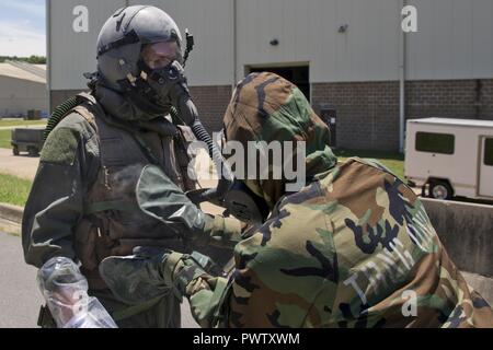 Le personnel de la réserve de l'US Air Force Sgt. Casey Godwin, équipages d'équipement de vol (AFE) Spécialiste, 327e Escadron de soutien des opérations des pats, vers le bas le s.. Michael Hopson, arrimeur, 327e Escadron de transport aérien, avec du charbon activé à partir d'un M295 Kit de décontamination individuelle lors d'un scénario d'instruction le 19 juin 2017, à la base aérienne de Little Rock, Ark. la formation nécessaire la construction de plusieurs systèmes de décontamination gonflable Léger (LIDS) refuges et l'élimination des contaminants à partir de la simulation de l'équipage de trois membres. Banque D'Images