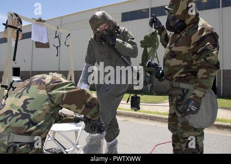 Le personnel de la réserve de l'US Air Force Sgt. Casey Godwin, prive les booties de sergent. Aaron Broge, arrimeur, 327e Escadron de transport aérien, de Tech. Le Sgt. David Underwood est titulaire d'un collecteur/Ventilateur boîtier intercom et pendant la formation de décontamination, le 19 juin 2017, à la base aérienne de Little Rock, Ark. Godwin et Underwood sont des spécialistes de l'équipement de vol du personnel navigant affecté à la 913e Escadron de soutien des opérations et ont participé à la formation d'améliorer leurs compétences dans la protection du personnel et leurs capacités à travailler efficacement et en toute sécurité dans un environnement contaminé. Banque D'Images