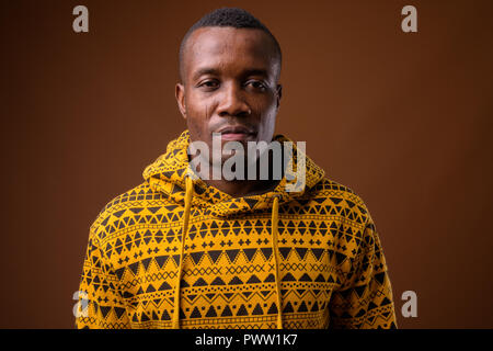 Portrait de jeune homme africain contre fond brun Banque D'Images