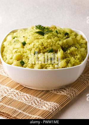 BATATA POHA fabriqués à partir de flocons de riz soufflé, de la pomme de terre et oignons. servi avec de la chaux et piments verts Banque D'Images