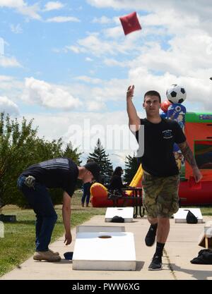 Aviateurs, jouer à un jeu de poches au cours de l'assiette annuelle pique-nique à Ellsworth Air Force Base, S.D., 30 juin 2017. L'événement comprenait une variété d'activités pour les aviateurs et leurs familles à participer à y compris le paintball, bubble soccer et maisons de rebond pour les enfants. Banque D'Images