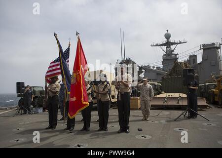 La mer d'Oman (1 juillet 2017) Les marins à la color guard détail au garde à vous pour l'hymne national à bord du USS Carter Hall (LSD 50), 1 juillet 2017, au cours d'une célébration de la fête de l'indépendance. 24e Marine Expeditionary Unit est actuellement déployée dans la 5e flotte américaine zone d'opérations à l'appui d'opérations de sécurité maritime visant à rassurer les alliés et les partenaires et de préserver la liberté de navigation et la libre circulation du commerce dans la région. Banque D'Images