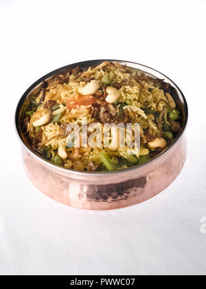 BIRYANI DE LÉGUMES SERVI DANS UN HANDI EN CUIVRE. Il EST FAIT AVEC DU RIZ ET LÉGUMES MIXTES LACÉE AVEC MASSALA ET GARNIE DE NOIX ET RAISINS SECS Banque D'Images