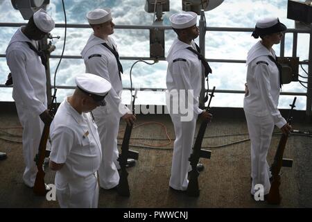 SURIGAO STRAIT (3 juillet 2017) marins affectés au porte-avions USS Nimitz (CVN 68), observer un moment de silence au cours d'une bataille de Golfe de Leyte Cérémonie de commémoration sur la plage arrière, le 3 juillet 2017, dans le dans le détroit de Surigao. La bataille de Golfe de Leyte a fait rage à partir de 23-26 octobre 1944, opposant la marine impériale japonaise contre les forces alliées des États-Unis et l'Australie et a été le dernier grand navire de l'engagement dans l'histoire. Nimitz est actuellement en déploiement dans la 7e flotte américaine zone d'opérations. La Marine américaine a patrouillé les Indo-Asia régulièrement du Pacifique pendant plus de 70 ans Banque D'Images