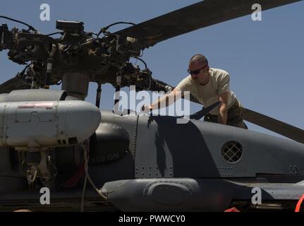 Un aviateur du 83e Escadron de sauvetage expéditionnaire procède à l'entretien de routine sur le HH-60G Pave Hawk sur l'aérodrome de Bagram, en Afghanistan, le 4 juillet 2017. Le QRE 83e est en appel en tout temps, ne jamais savoir quand ils pourraient recevoir l'appel pour sauver les troupes au sol qui ont besoin de soins médicaux urgents. L'équipage d'assurer la maintenance et le HH-60 est prêt à tout moment pour quand cet appel n'arrivent. Banque D'Images