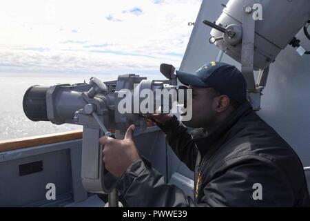 Océan Atlantique (29 juin 2017) - Le lieutenant J.G. Brice Musgrove, de Dallas, utilise la marque III MOD V monté à bord du navire des jumelles la classe Arleigh Burke destroyer lance-missiles USS James E. Williams (DDG 95) pendant l'exercice 17 (DYMON Dynamique Mongoose17) Le 29 juin 2017. DYMON17 est dirigée par l'OTAN chaque année un exercice de guerre anti-sous-marine conçu pour offrir des possibilités de formation à l'unité vers le groupe de niveau et aiguiser la lutte anti-sous-/anti-surface compétences de guerre des unités participantes. ( Banque D'Images