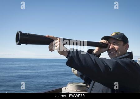 Mer de Norvège (30 juin 2017) Quartier-maître 2e classe Brandon, eaux de Orlando, pairs au moyen d'une longue-vue à bord de la classe Arleigh Burke destroyer lance-missiles USS Ross (DDG 71) comme le navire transite la mer de Norvège le 30 juin 2017. Ross, l'avant-déployé à Rota, Espagne, mène des opérations navales dans la sixième flotte américaine zone d'opérations à l'appui de la sécurité nationale des États-Unis en Europe et en Afrique. ( Banque D'Images