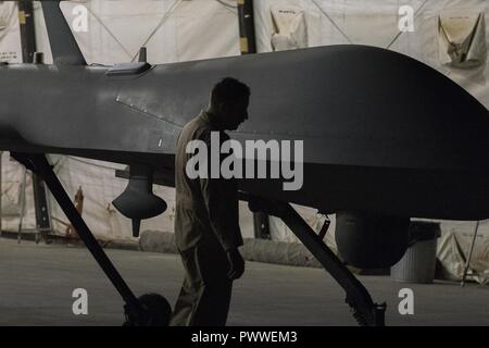 Le lieutenant-colonel Douglas, 361e Escadron d'attaque, le commandant de la Force expéditionnaire du Canada inspecte un prédateur MQ-1B après son dernier vol de combat affecté à la 361e EATKS, Juillet 2, 2017, dans le sud-ouest de l'Asie. Dans les 18 mois, le MQ-1B a été affecté à la 361e Escadron de reconnaissance de la force expéditionnaire, ultérieurement désigné comme le 361EATKS, son équipage a effectué l'avion sur plus de 2 000 missions de combat, 36 000 heures de reconnaissance et d'attaque de persistance, et a tiré 358 missiles AGM-114 Hellfire, contribuant considérablement à la lutte contre l'ISIS. Banque D'Images