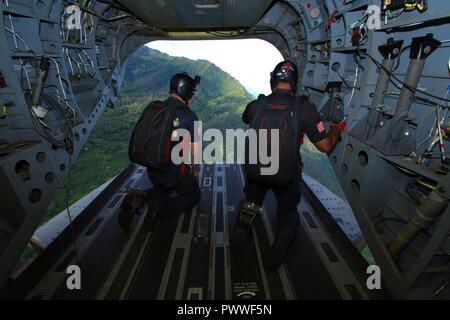 SCHOFIELD BARRACKS, New York -membres de l'équipe de l'US Army Special Operations Command Équipe de démonstration de parachutisme, le noir de poignards, regarder vers le bas à leur zone de liste déroulante d'un CH-47 Chinook 4 juillet 2017, avant leur show au cours de la célébration de la Journée de l'indépendance à Schofield Barracks. Les poignards noire effectuer des sauts haute altitude ouverture basse à l'appui d'opérations spéciales de recrutement et de relations communautaires. Banque D'Images