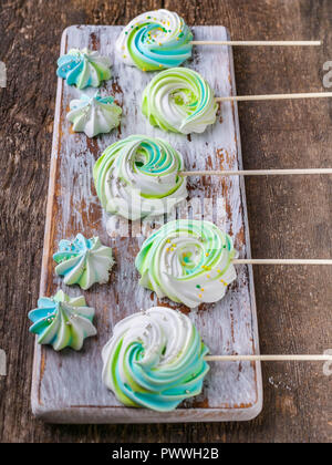 Meringues colorées sur un fond de bois. Bonbons traditionnels français. Shot verticale Banque D'Images