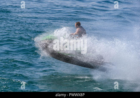 Le lac de Garde, ITALIE - Septembre 2018 : jet ski et le cavalier couvert par une vague de saut après pulvérisation sur le lac de Garde. Banque D'Images