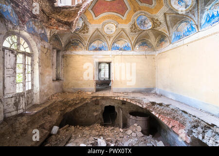 Vue intérieure d'une villa abandonnée avec des trous dans le sol en raison d'un tremblement de terre en Italie. Banque D'Images