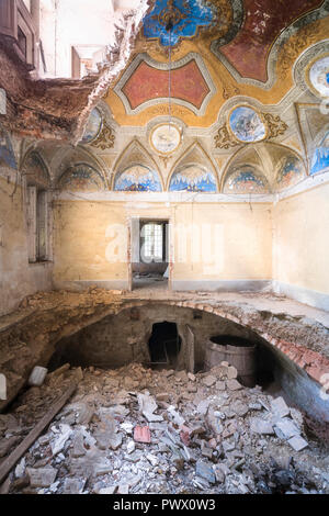 Vue intérieure d'une villa abandonnée avec des trous dans le sol en raison d'un tremblement de terre en Italie. Banque D'Images