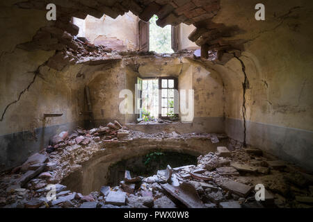 Vue intérieure d'une villa abandonnée avec des trous dans le sol en raison d'un tremblement de terre en Italie. Banque D'Images