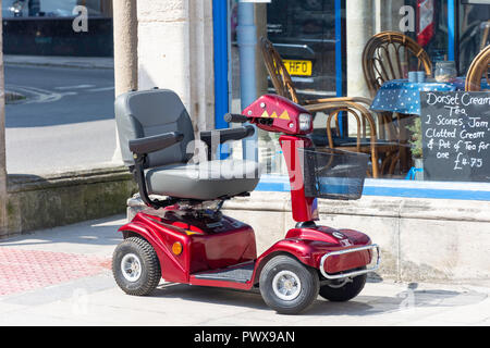 Scooter de mobilité à l'extérieur cafe, High Street, Swanage, à l'île de Purbeck, Dorset, Angleterre, Royaume-Uni Banque D'Images