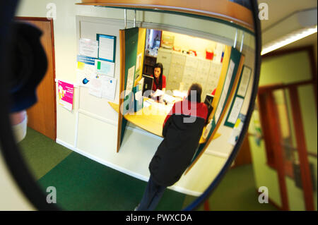 Mauvais patient parle au standardiste dans une chirurgie GP DU NHS au Royaume-Uni avant de se joindre à la patients en attente Banque D'Images