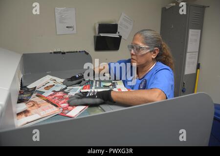 Graciela Pena et magazines papier met en un grand shredder 28 Juin à Brooke Army Medical Center. BAMC recycle une moyenne de 12 000 livres de carton et papier déchiqueté d'un mois. (U. S. Army Banque D'Images