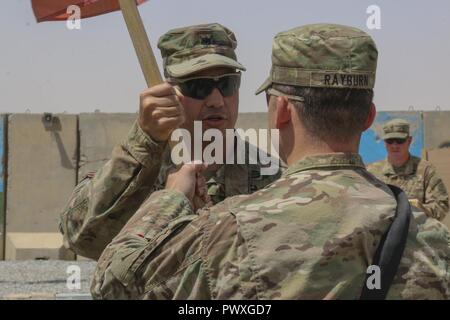 Le Lieutenant-colonel de l'armée américaine Sebastian Pastor, commandant du 37e bataillon du génie, 82e Division aéroportée, passe la Compagnie Alpha guidon à l'armée américaine le Capitaine Scott Rayburn, le nouveau commandant, au cours d'une cérémonie de passation de commandement à Qayyarah aérodrome Ouest, l'Iraq, le 1 juillet 2017. La soeur de M. Rayburn, le capitaine de l'armée américaine Whitmore Kaitlin, commandant de la Compagnie Charlie, 215e Bataillon de soutien de la Brigade Blindée, 3e Brigade Combat Team, 1re Division de cavalerie, a voyagé de son emplacement de déploiement au Koweït à l'Irak de chez son frère premier changement de commandement. Banque D'Images