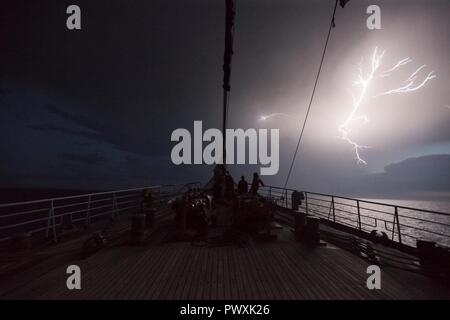 Coast Guard Academy Cadets se regarder dans une tempête au cours d'été des cadets à bord du garde-côte de barque Eagle dans l'océan Atlantique Nord, le 28 juin 2017. Au cours du programme de formation de cinq semaines, les cadets ont enseigné les rudiments en matelotage, l'ingénierie, la navigation et le contrôle des dommages. Banque D'Images