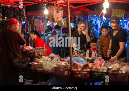 Les touristes et les populations locales de prendre un regard sur les souvenirs et d'autres marchandises dans le célèbre marché de nuit de Riverside à Vientiane, Laos, la nuit. Banque D'Images