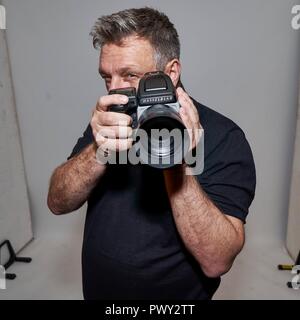 Berlin, Deutschland. 17 Oct, 2018. Exclusif : 17.10.2018, meilleur photographe John Rankin Waddell 'Rankin' a été réservé à la toile Bombay Sapphire Bar à Berlin. Portrait exclusif du photographe avec son appareil photo Hasselblad en face de son travail. En Allemagne, Rankin est également connu pour ses emplois en France's Next Top Model. Utilisation dans le monde entier | Credit : dpa/Alamy Live News Banque D'Images