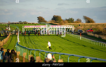 Brighton, UK. 18 Oct, 2018. Le soleil se couche sur la saison de course à Brighton cet après-midi que les jockeys la tête en bas, la colline en direction de la finale pour la dernière fois cette année Crédit : Simon Dack/Alamy Live News Banque D'Images