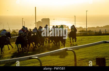 Brighton, UK. 18 Oct, 2018. Le soleil se couche sur la saison de course à Brighton cet après-midi que les jockeys la tête en bas, la colline en direction de la finale pour la dernière fois cette année Crédit : Simon Dack/Alamy Live News Banque D'Images