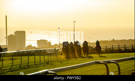 Brighton, UK. 18 Oct, 2018. Le soleil se couche sur la saison de course à Brighton cet après-midi que les jockeys la tête en bas, la colline en direction de la finale pour la dernière fois cette année Crédit : Simon Dack/Alamy Live News Banque D'Images