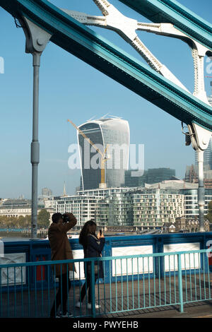 Un couple de touristes à prendre des photos sur le Tower Bridge avec le bâtiment de talkie-walkie 20 Fenchurch Street City de Londres Angleterre Royaume-Uni UK Banque D'Images