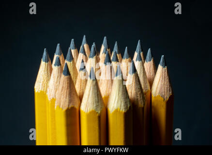 Groupe des crayons de couleur jaune avec des conseils aiguisés vers le haut sur fond noir Banque D'Images